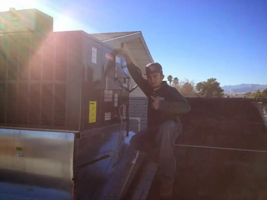 HVAC technician performing AC Tune-Up on a rooftop unit in Oak Park